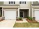 Close-up of a townhome showcasing a garage, front door, and landscaped entry at 2749 Yeager Nw Dr, Concord, NC 28027