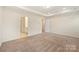 Carpeted main bedroom with tray ceiling and ensuite bathroom access at 2749 Yeager Nw Dr, Concord, NC 28027