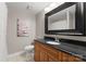 Well-maintained bathroom with black granite vanity, a framed mirror, and neutral-toned walls at 300 W 5Th St # 224, Charlotte, NC 28202