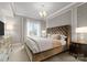 Elegant bedroom featuring a tufted headboard, patterned accent wall, and natural light from the large window at 300 W 5Th St # 224, Charlotte, NC 28202