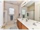 Bathroom with double vanity, large mirror, and tub/shower combo with white tile at 306 Ashby Dr, Davidson, NC 28036