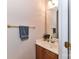 Half bathroom with wooden vanity, countertop sink, large mirror, and brass hardware at 306 Ashby Dr, Davidson, NC 28036