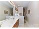 Long bathroom with double vanity, large mirror, and walk-in shower in neutral colors at 306 Ashby Dr, Davidson, NC 28036