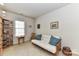 Bright bedroom with a futon, large window, and a bookshelf filled with books at 306 Ashby Dr, Davidson, NC 28036