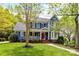 Charming two-story home with a welcoming front porch, red door, and well-manicured lawn at 306 Ashby Dr, Davidson, NC 28036