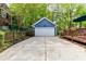 Detached garage with white door, adjacent deck, and ample driveway parking, surrounded by lush greenery at 306 Ashby Dr, Davidson, NC 28036