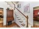 Carpeted staircase with white banisters, hardwood floors, and a wooden display cabinet at 306 Ashby Dr, Davidson, NC 28036
