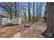 Spacious backyard with a storage shed, fire pit area, and plenty of trees and foliage at 310 Pineview St, Kannapolis, NC 28083