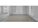 Open-concept living room with neutral carpet, built-ins, and windows at 310 Pineview St, Kannapolis, NC 28083