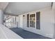 View of covered porch with painted deck, pillars, railing, and white door at 310 Pineview St, Kannapolis, NC 28083