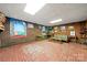 Large basement featuring a brick floor, wood paneling, and decorative art at 32 Fairway Rdg, Lake Wylie, SC 29710