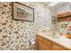 Charming bathroom with floral wallpaper, artwork, and a cream-colored countertop at 32 Fairway Rdg, Lake Wylie, SC 29710
