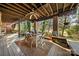 Covered outdoor patio with seating and views of the wooded backyard at 32 Fairway Rdg, Lake Wylie, SC 29710
