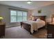 A warm-toned bedroom featuring a wooden bed frame and a sunny window at 3304 Taviston Dr, Waxhaw, NC 28173