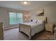 Cozy bedroom with neutral walls, a large window and a light colored wooden bed frame at 3304 Taviston Dr, Waxhaw, NC 28173