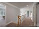 Hallway with neutral walls and carpet leading to multiple rooms, with white railing at 3304 Taviston Dr, Waxhaw, NC 28173