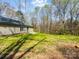 Home's verdant backyard features a lush lawn and natural backdrop of mature trees at 350 Belvedere Nw Dr, Concord, NC 28027
