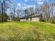 Quaint single-story home showcasing a grassy lawn and idyllic setting amidst mature trees and blue skies at 350 Belvedere Nw Dr, Concord, NC 28027