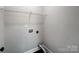 Neutral-toned laundry room features a functional layout with a white wire shelf and utility hookups at 350 Belvedere Nw Dr, Concord, NC 28027