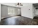 Bright, neutral living room with hardwood floors, large windows, a ceiling fan, and a white front door at 350 Belvedere Nw Dr, Concord, NC 28027