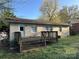 Backyard with a weathered wooden deck attached to the home; lawn in need of care at 3915 Crestridge Dr, Charlotte, NC 28217