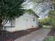 This backyard features an access door on the side of the white brick building with a grassy area at 3915 Crestridge Dr, Charlotte, NC 28217