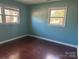 Cozy bedroom featuring updated hardwood floors and two windows that bring in natural light at 3915 Crestridge Dr, Charlotte, NC 28217