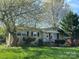 A cute single-story home with brick exterior, well-manicured lawn, and lush green shrubbery at 3915 Crestridge Dr, Charlotte, NC 28217