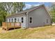Backyard featuring a wood deck, light gray siding and several windows along the back of the home at 409 Bost St, Kannapolis, NC 28081