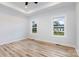 Bright bedroom featuring a tray ceiling, wood-look floors, and large windows for natural light at 409 Bost St, Kannapolis, NC 28081