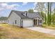 Side view of a house with gray siding, black roof, and a white two-car garage at 409 Bost St, Kannapolis, NC 28081