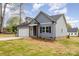 Cozy home featuring gray siding, a black roof, and well-maintained landscaping at 409 Bost St, Kannapolis, NC 28081