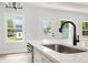 Modern kitchen island with sleek black faucet, stainless steel dishwasher, and quartz countertop at 409 Bost St, Kannapolis, NC 28081