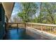 This covered back porch has a tile floor and wooden railing with trees at 4931 Galax Dr, Charlotte, NC 28213