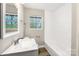 Updated bathroom featuring a bright vanity, framed mirror, and a bright window view at 4931 Galax Dr, Charlotte, NC 28213