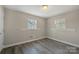 Bright bedroom with gray wood flooring and natural light from two windows at 4931 Galax Dr, Charlotte, NC 28213