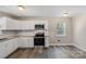 Updated kitchen boasts white cabinetry, stainless appliances, granite countertops, and bright lighting at 4931 Galax Dr, Charlotte, NC 28213