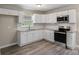 Updated kitchen with white cabinetry, stainless appliances, granite countertops, and wood-look floors at 4931 Galax Dr, Charlotte, NC 28213