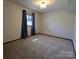 Bright bedroom with neutral carpet and a window with curtains, creating a calming space at 5412 Carving Tree Dr, Harrisburg, NC 28075