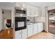 Bright kitchen featuring white cabinetry, granite countertops, stainless steel appliances, and hardwood flooring at 5412 Carving Tree Dr, Harrisburg, NC 28075