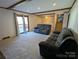 Spacious living room with neutral carpet, wood beam ceilings, comfortable couches and access to an outdoor deck at 5412 Carving Tree Dr, Harrisburg, NC 28075