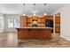 Bright kitchen with a large central island, wooden cabinets, pendant lighting, and modern flooring at 6615 Buck Horn Pl, Waxhaw, NC 28173
