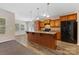 Spacious kitchen with a large central island, wood cabinets, black appliances, and view to the dining area at 6615 Buck Horn Pl, Waxhaw, NC 28173