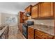 Kitchen boasts wooden cabinets, laminate countertops, and black appliances, with a view to the dining area at 6615 Buck Horn Pl, Waxhaw, NC 28173