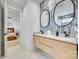Contemporary bathroom featuring a double vanity with round mirrors and modern tile backsplash at 805 E 19Th St, Charlotte, NC 28205