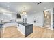 Modern kitchen boasts an island with seating, stainless steel appliances, and access to the staircase at 805 E 19Th St, Charlotte, NC 28205