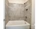 Clean white bathtub with tiled walls and decorative mosaic border at 8513 Garden View Dr, Charlotte, NC 28277
