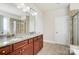 Bathroom featuring double sink vanity and walk-in shower with stone tile at 8513 Garden View Dr, Charlotte, NC 28277