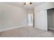 Bright bedroom features neutral walls, plush carpeting, ceiling fan, and closet at 8513 Garden View Dr, Charlotte, NC 28277