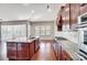 Modern kitchen with a granite island, cherry wood cabinetry, and stainless steel appliances at 8513 Garden View Dr, Charlotte, NC 28277